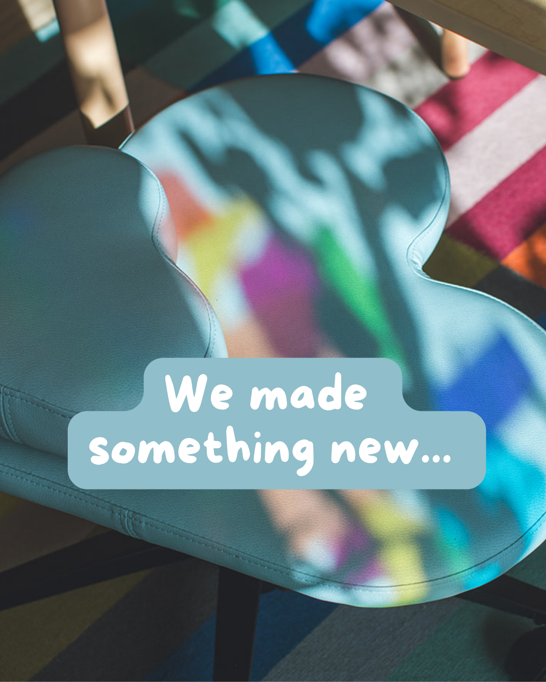 A close-up of a light blue fidget seat with a soft rounded shape, overlaid with the text 'We made something new.